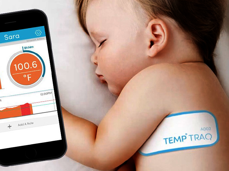 A baby sleeps with a Temp Traq patch on their upper arm. A smartphone app display shows a body temperature of 100.6°F, with a calming blue spark indicating the temperature status.